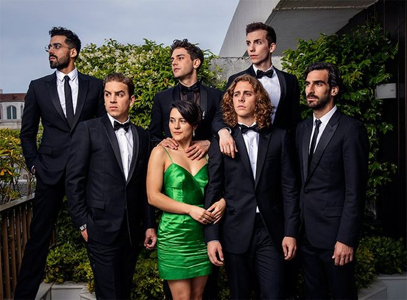 A group shot taken on a balcony, with all seven formally dressed people looking to one side. Photograph by Paolo Verzone on a Canon EOS R.