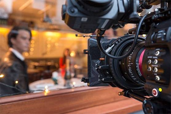 Filming the warmly-lit interior of a café through the window with a Canon EOS C700 FF camera and Sumire Prime cine lens.