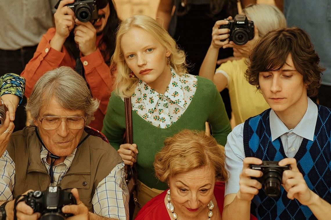 A woman in 1970’s-style clothes looks up from a crowd in a shot from Javier Cortés’s fashion film, Beauty is Subjective.