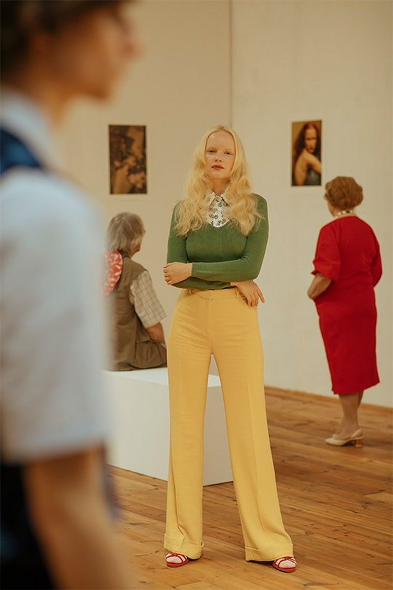 The blonde woman stands in an art gallery, photographed by Javier Cortés on a Canon EOS 5D Mark IV.