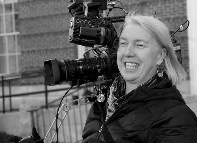 Cinematographer Claudia Raschke holding a cine camera.