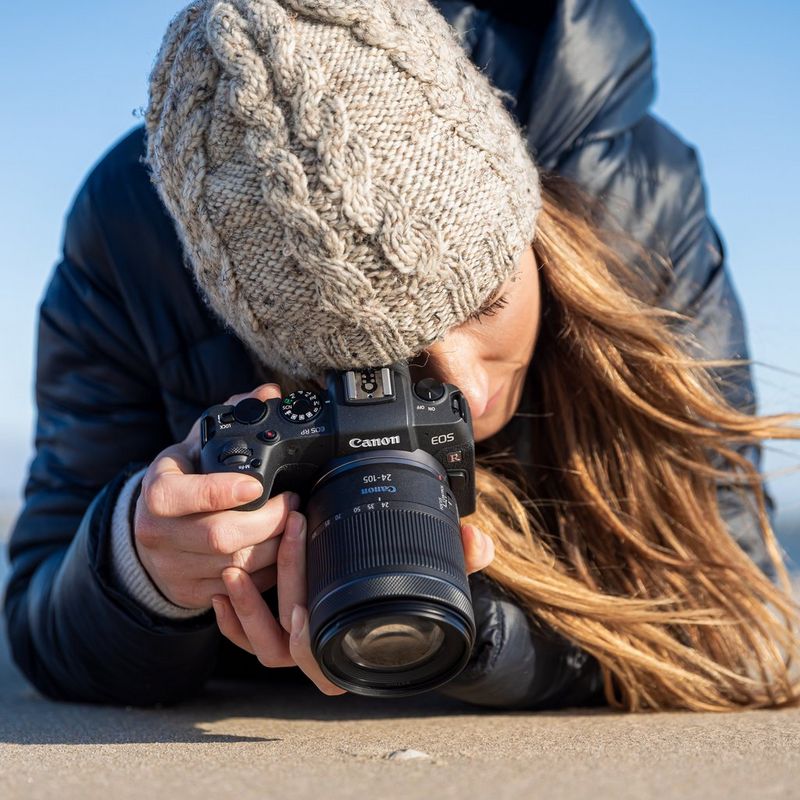 Lady wearing a grey beanie, blue coat and taking a shot on the йP with RF 24-105mm F4-7.1 IS STM