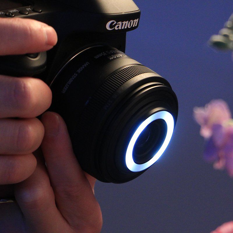 Somebody taking a macro picture with a Canon camera and lens EF-S 35MM F2.8 IS STM MACRO with a macro lite on.