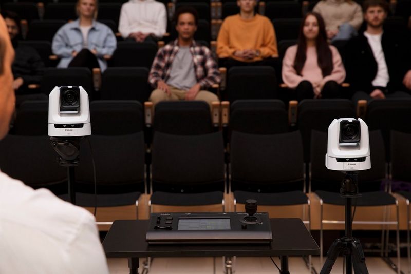 Two Canon CR-N300 PTZ cameras set up in a lecture theatre filled with students.