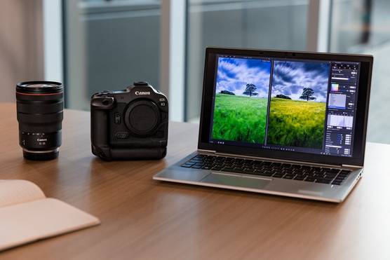 A laptop sits open with a landscape image being edited in Digital Photo Professional software on screen, with a Canon EOS R3 camera and RF 15-35mm F2.8L IS USM lens on the desk alongside.