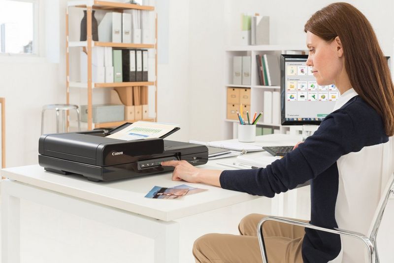 Work professional using Canon CaptureOnTouch Pro to efficiently scan and organise document batches with user-friendly, productive software