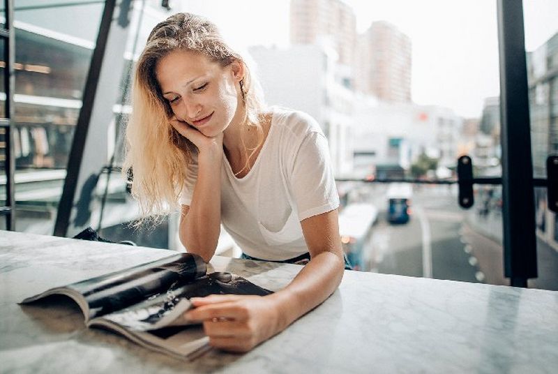 woman looking through a printed promotional book