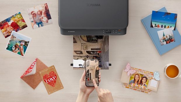 A flat lay image of a PIXMA printer, printing out holiday pictures, surrounded by other printed pictures.