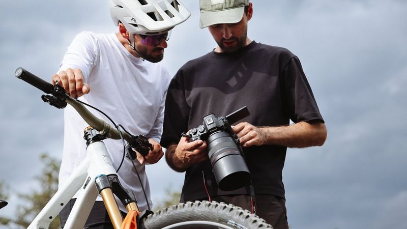A mountain biker reviewing images with a photographer on a Canon camera