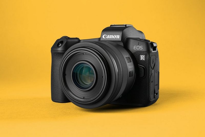 Canon EOS R mirrorless camera with attached lens on a yellow background