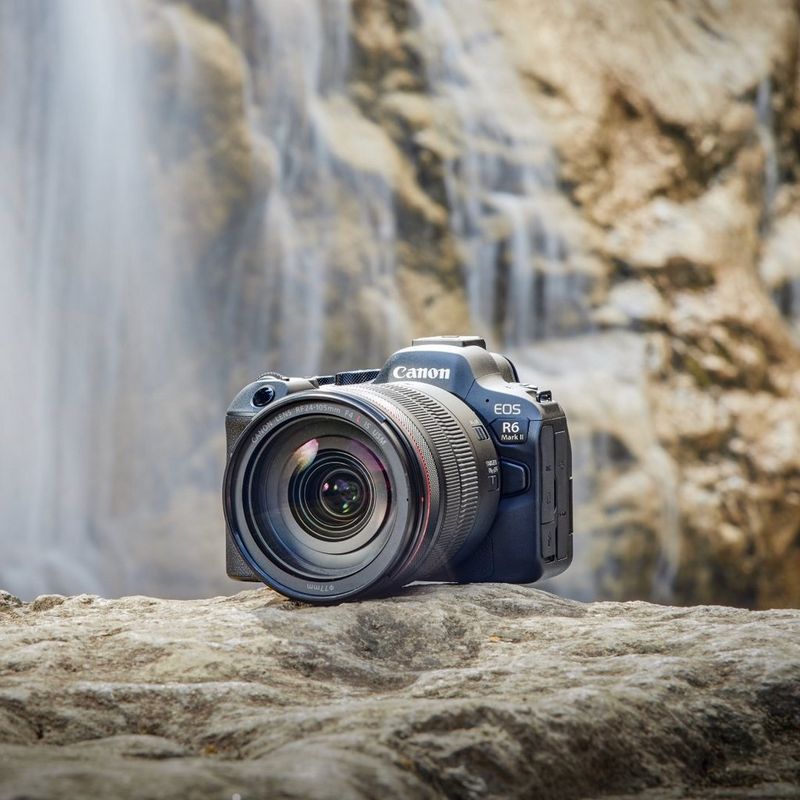 Canon EOS R6 Mark II camera on a rock with a blurred waterfall in the background