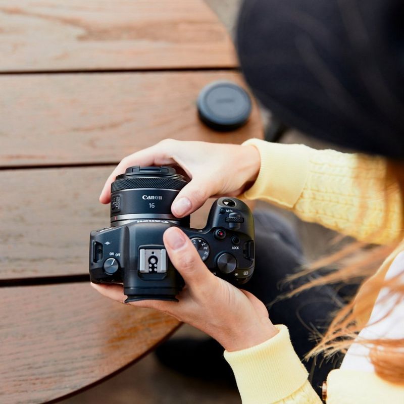 Osoba podłączająca obiektyw RF 16mm F2.8 STM do aparatu Canon.