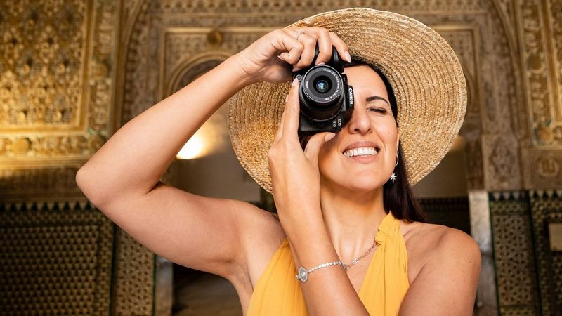 Une personne utilisant le Canon EOS R10 pour prendre une photo à l'intérieur d'une pièce très décorée