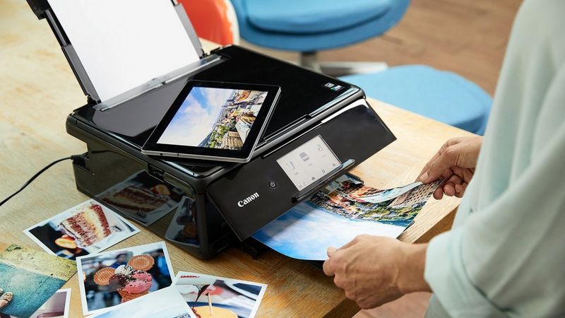 En person, der bruger Canon PRINT-appen på en tablet til at printe levende fotos på en PIXMA-printer.