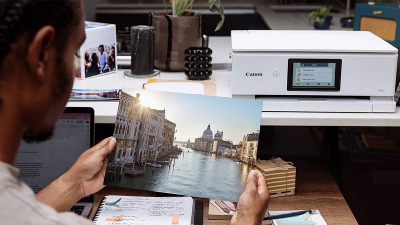 PIXMA-printer, der producerer langtidsholdbare fotoprint, en person, der holder et farverigt billede af Venedig.