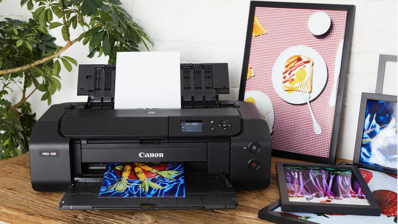 Printer i PIXMA PRO-serien på et skrivebord med farverige fotoprint.