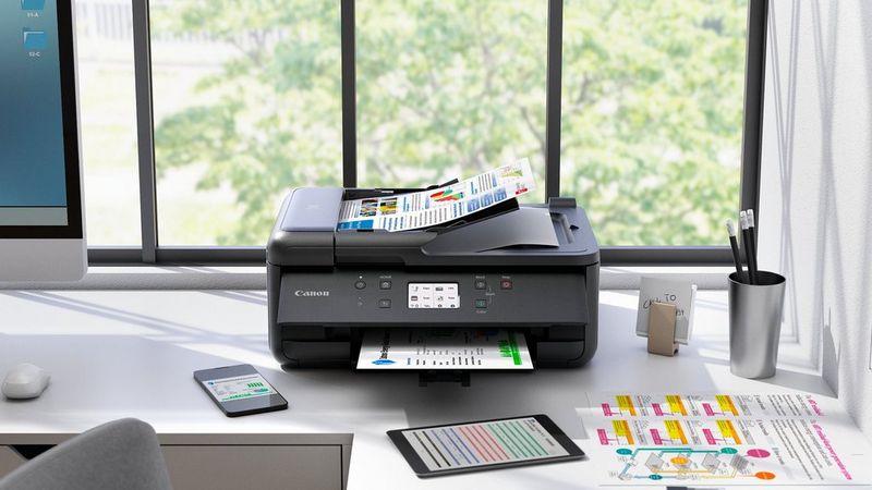 PIXMA-printer i et lille kontormiljø med diagrammer, tablet og kontorartikler på skrivebordet.
