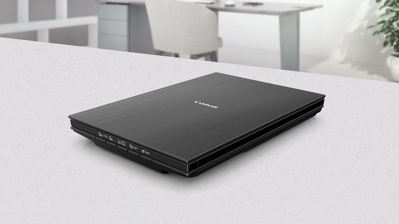 Canon CanoScan LiDE 400 flatbed scanner on a desk in a clean office workspace.