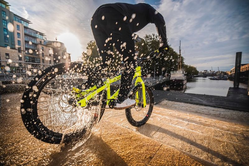 Scatto d'azione realizzato con Canon Speedlite EL-1 che mostra un rider che salta su gradini di pietra e schizzi d'acqua immortalati dal flash.