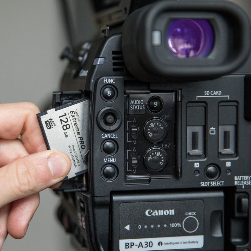 128 GB SD card being slotted into Canon video Camera.