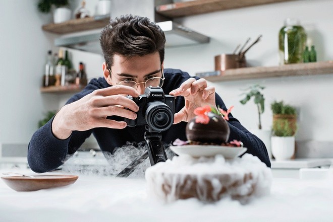 رجل يلتقط صورًا لحلوى الشوكولاتة على طبق يحيط به ثلج جاف.