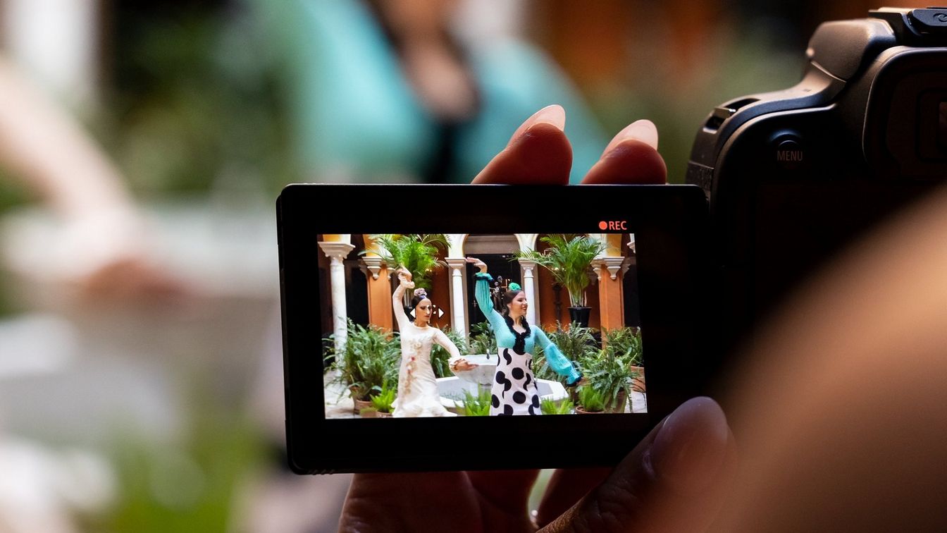 منظر من زاوية مرتفعة فوق كتف المصور لشاشة LCD في كاميرا EOS R10 من Canon تعرض اثنين من راقصي الفلامنكو يتم تصويرهما.