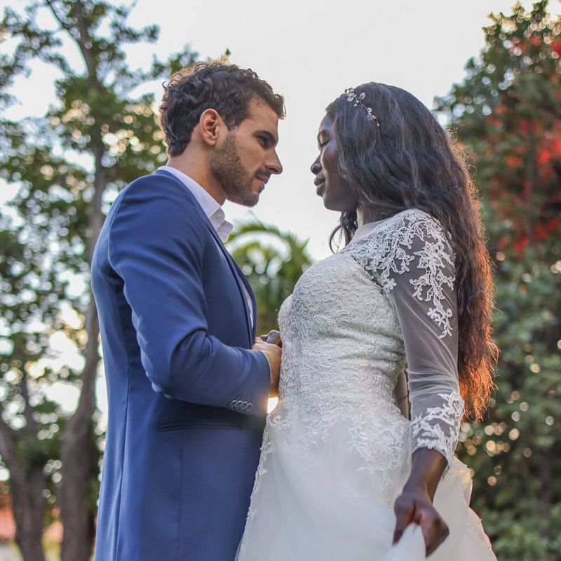A bride and groom look into each other's eyes, with trees in the background.