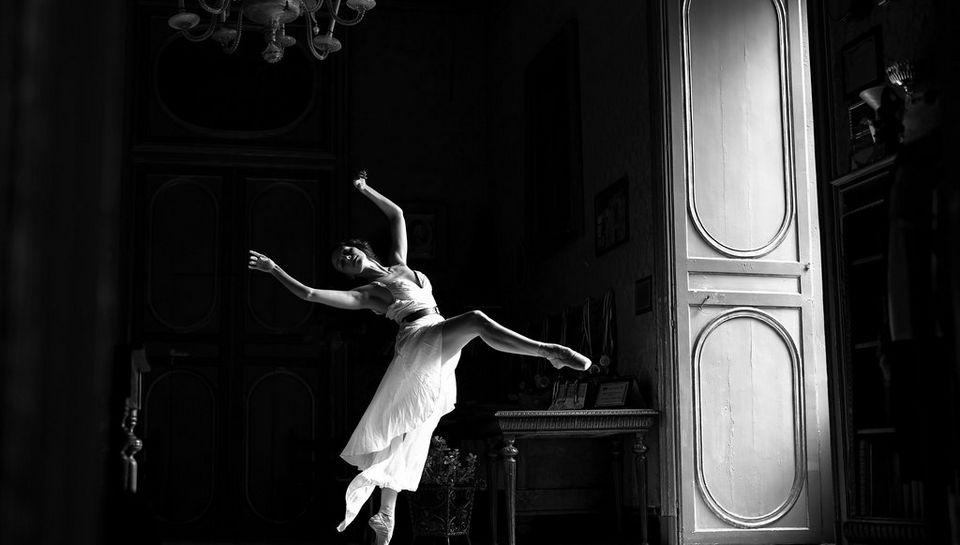 Ballet performance against a dark room backdrop
