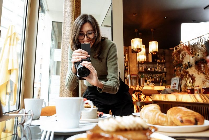 Laura Hannoun smiles as she photographs a spread of coffee and croissants in a Paris café.