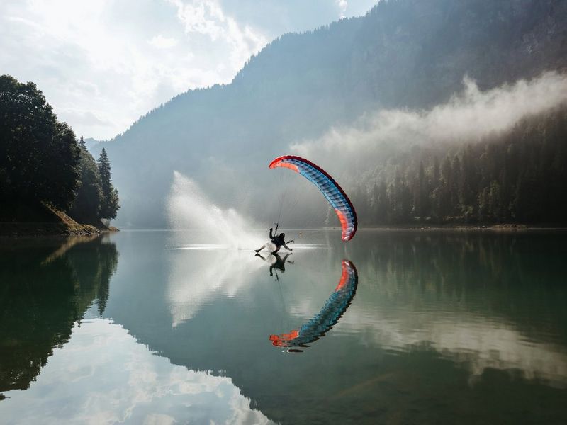 Man paragliding over a lake 