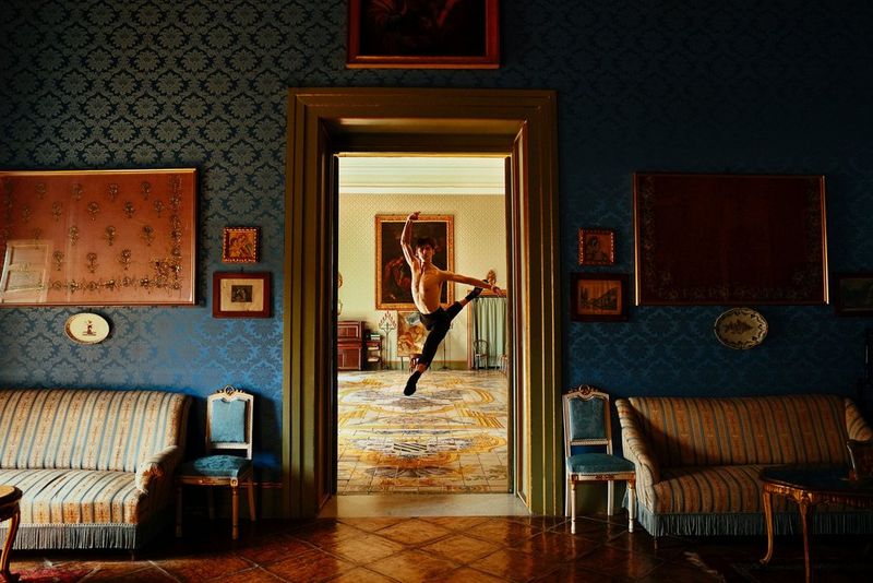 A ballet dancer in an adjacent room is captured framed in the doorway.