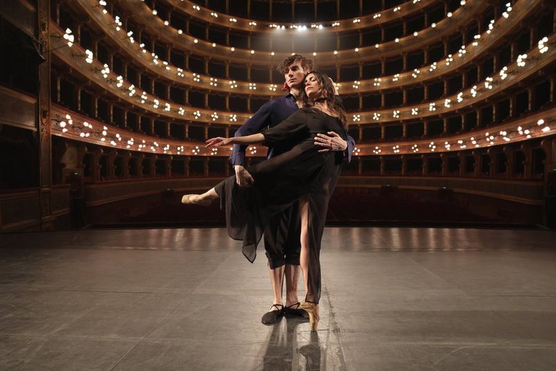 Two ballet dancers pose together on stage at the Teatro Massimo, Sicily.
