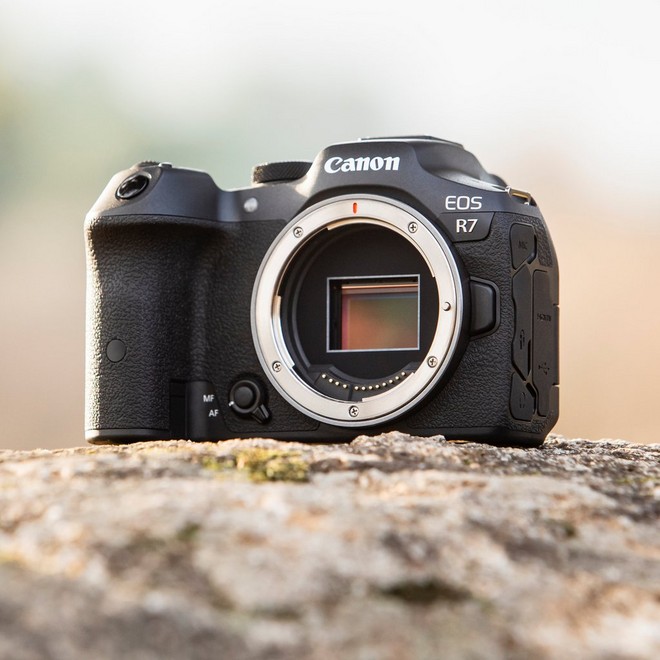 كاميرا EOS R7 من Canon توجد على صخرة. إنها غير مزوّدة بعدسة، ولذا يمكن رؤية المستشعر بالداخل.