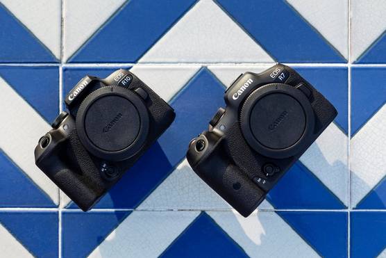 The EOS R7 and EOS R10 on a surface tiled in a bright blue and white chevron pattern.