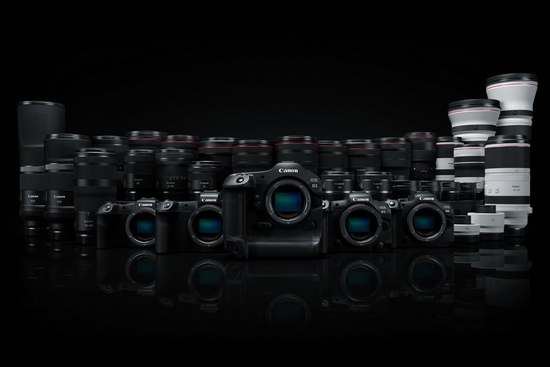 A row of Canon ֽ_격- System cameras displayed in front of a row of RF lenses.