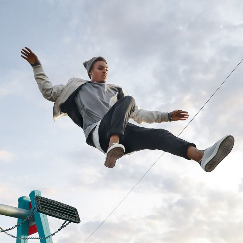 Boy jumping off a park swing