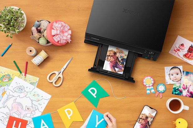 A Canon PIXMA TS6350 Series printer surrounded by papercraft materials, pencils and a pair of scissors.