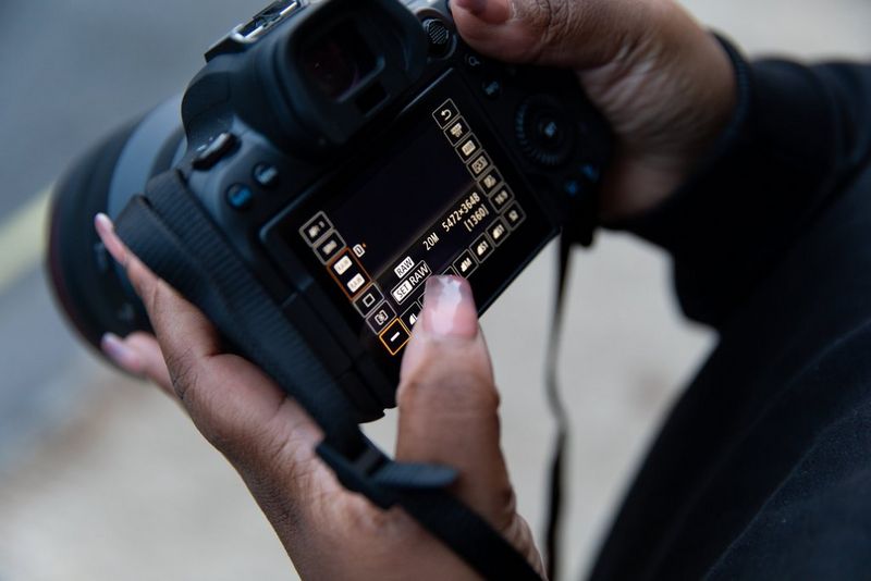 شخص يمسك بكاميرا EOS R6 من Canon ويضبط إعداد الكاميرا لالتقاط صور بتنسيق RAW.
