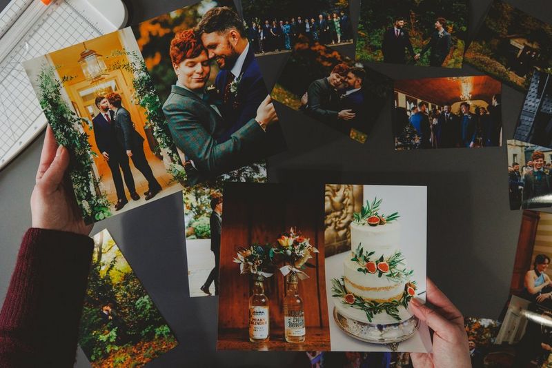 يدان تحملان مجموعة من صور يوم زفاف من بينها صورة للعروسين وهما يتعانقان وكعكة زفاف من ثلاثة أدوار.