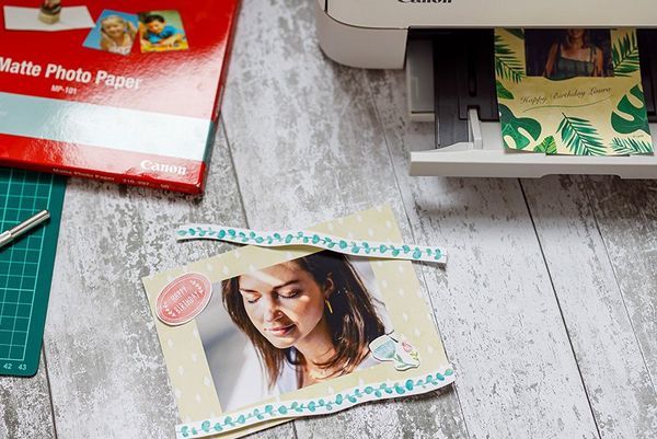 A personalised card created with the Creative Park app next to a Canon printer. 
