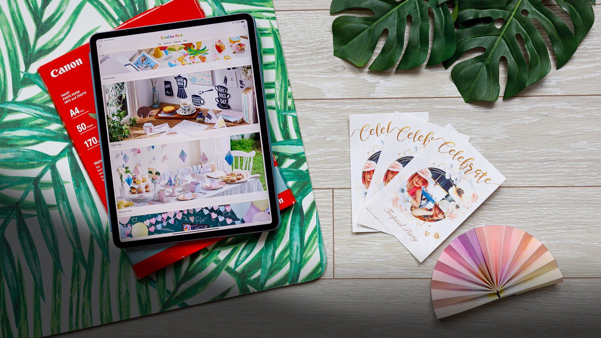 A tablet showing the Creative Park app next to personalised cards and a party garland.