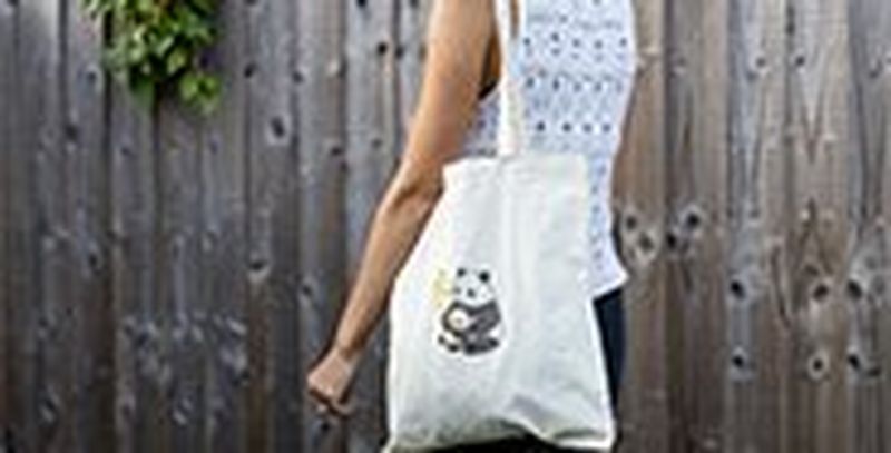 A woman carries a tote bag which has been customised with a panda motif from Creative Park with Canon's iron-on transfers.