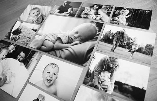 Black and white prints of children and families arranged in a grid style on the floor.