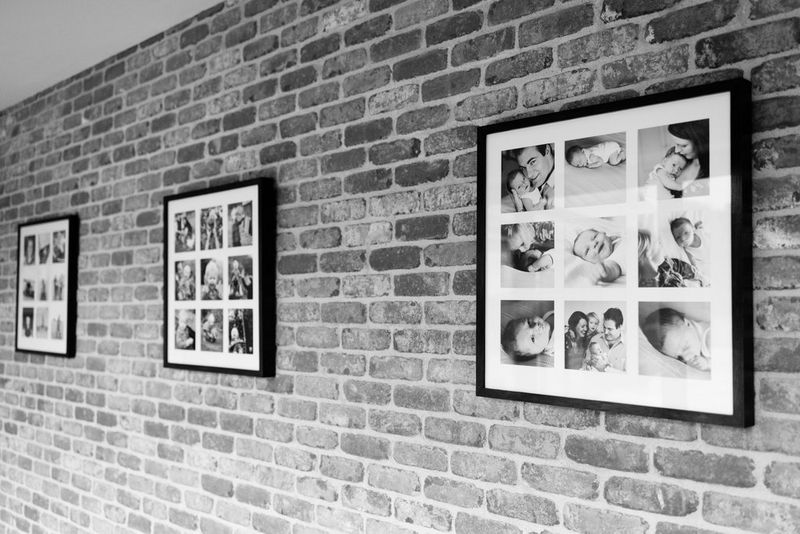 صور أطفال وعائلات بالأبيض والأسود مطبوعة ومنظمة على شكل شبكة ضمن ثلاثة إطارات على جدار من القرميد.