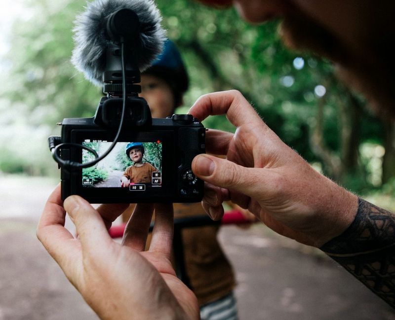 Vlogger Stef Michalak filming his young son as he rides a balance bike.