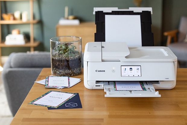 A Canon printer on a table in a living room.