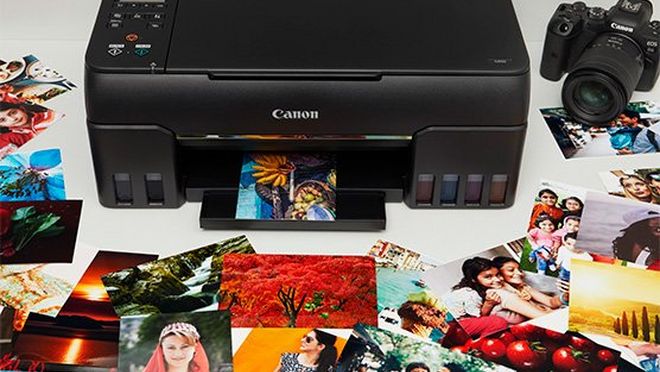 Принтер Canon PIXMA G540 в окружении красочных печатных фотографий 10x15 см.