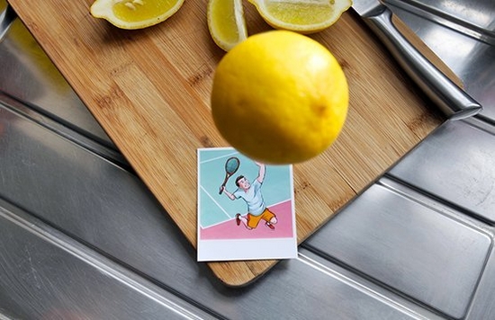 A lemon hovers in the air above an illustrated print of a tennis player about to serve. The effect makes it look as if the player is about to hit the lemon.