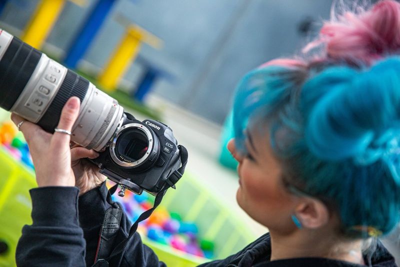 Фотограф домашних животных Кэт Рэйс устанавливает объектив EF на камеру Canon EOS R6 с помощью адаптера крепления Canon EF-EOS R.