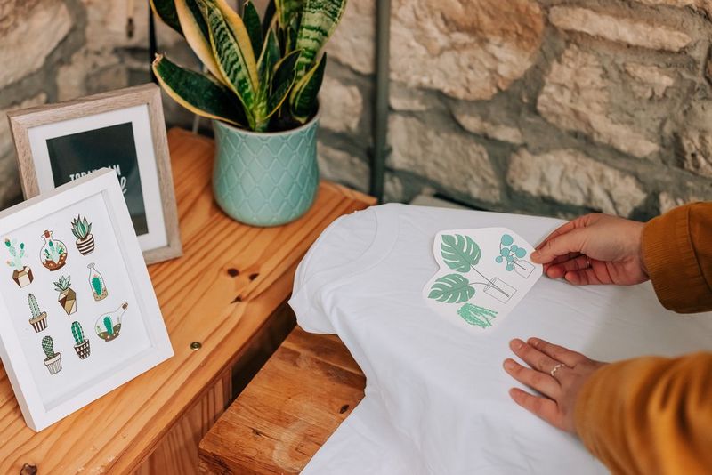 A woman positioning a houseplant design on a T-shirt.